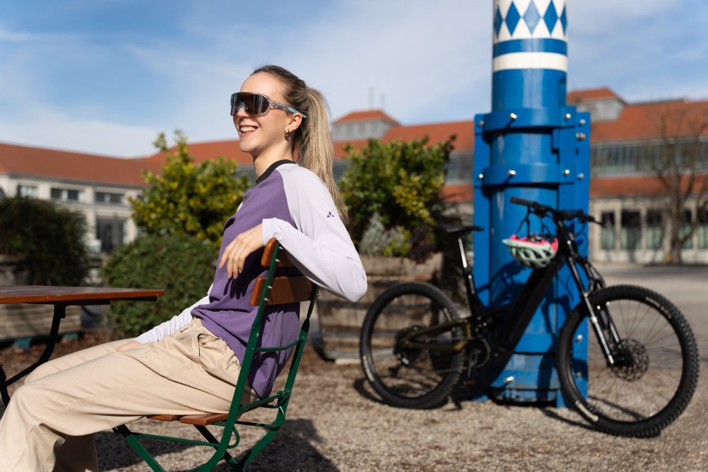 Frau macht Pause von einer Fahrradtour im Biergarten bei Sonnenschein.